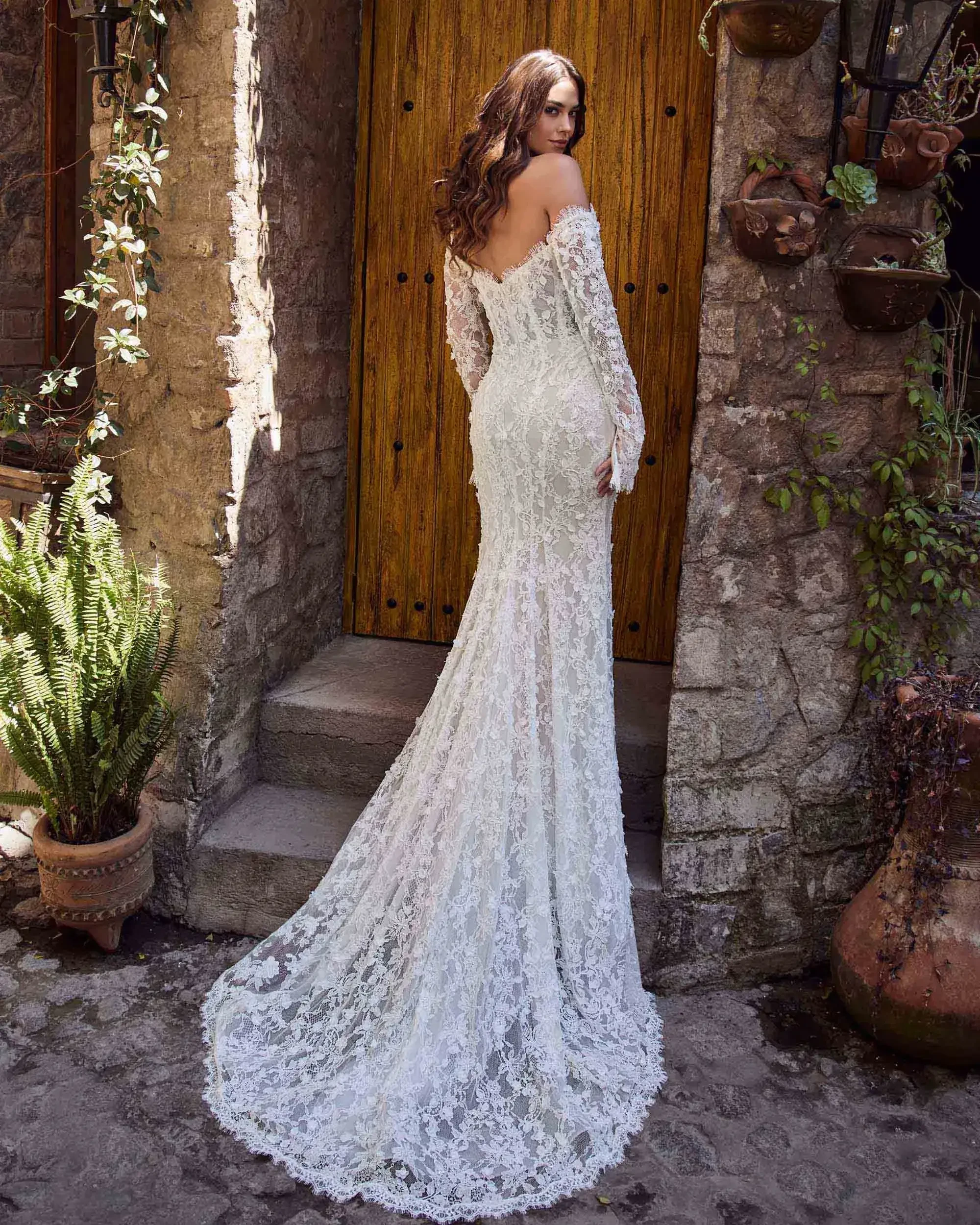 model is wearing a strapless lace bridal gown with detachable sleeves