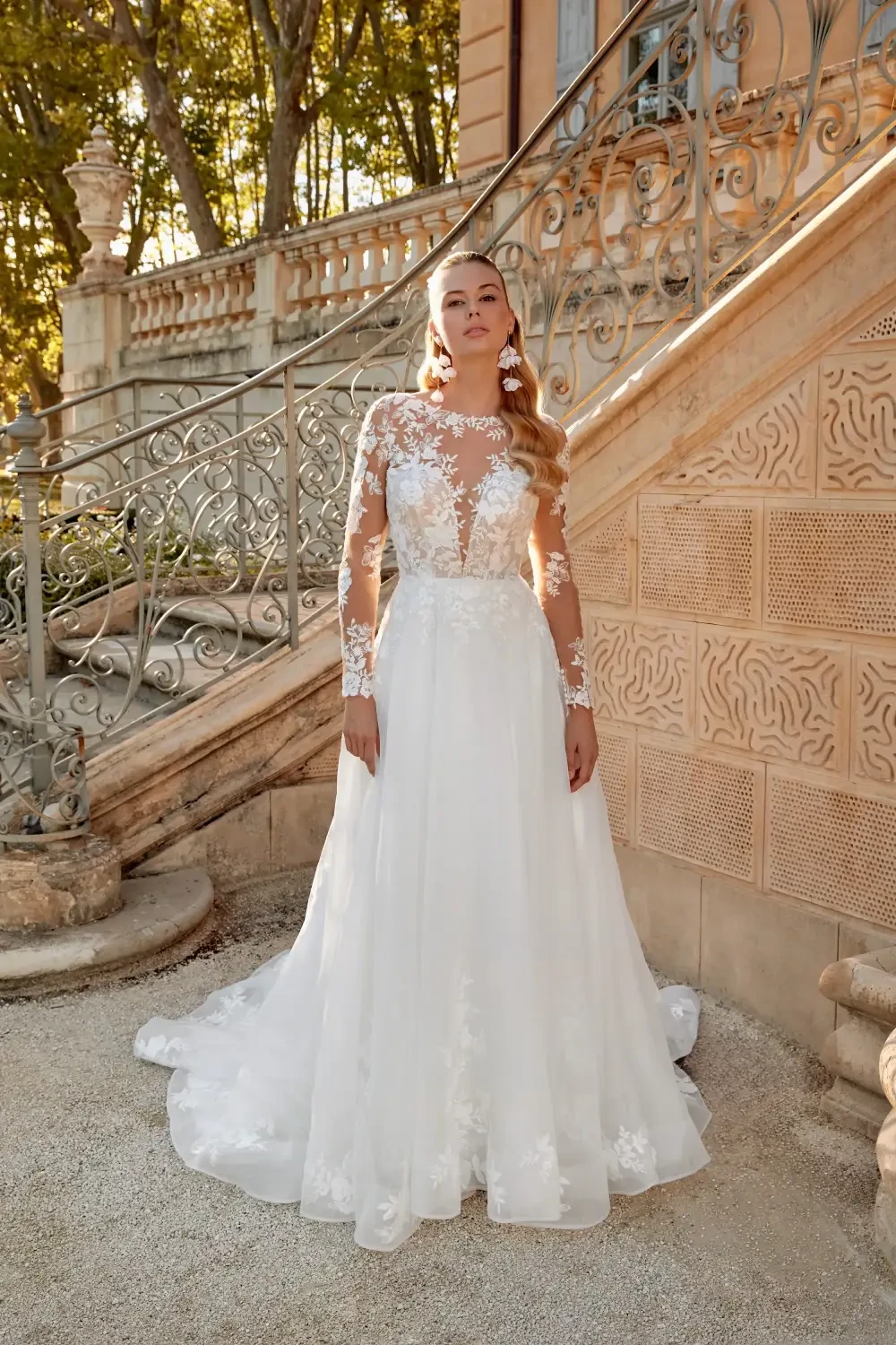 model is wearing an illusion sleeve bridal gown