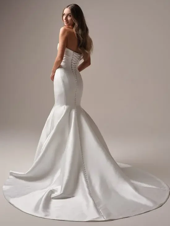 Model is wearing a strapless fit-and-flare gown with a sweetheart neckline, banded corset back, and sustainable fabrics for modern romance.