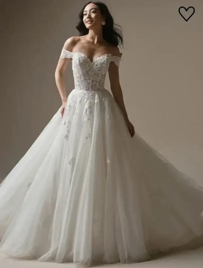 A woman wearing an elegant off-the-shoulder wedding dress with a fitted bodice and a flowing tulle skirt.