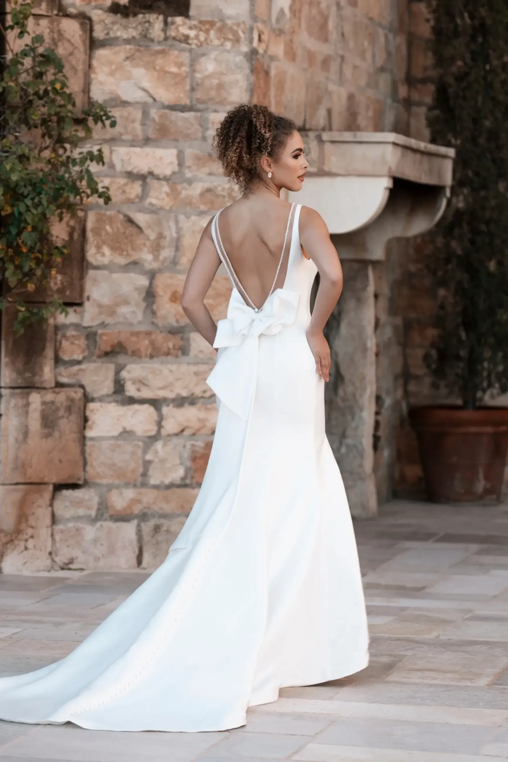 Model is wearing a beaded fit and flare mikado wedding dress