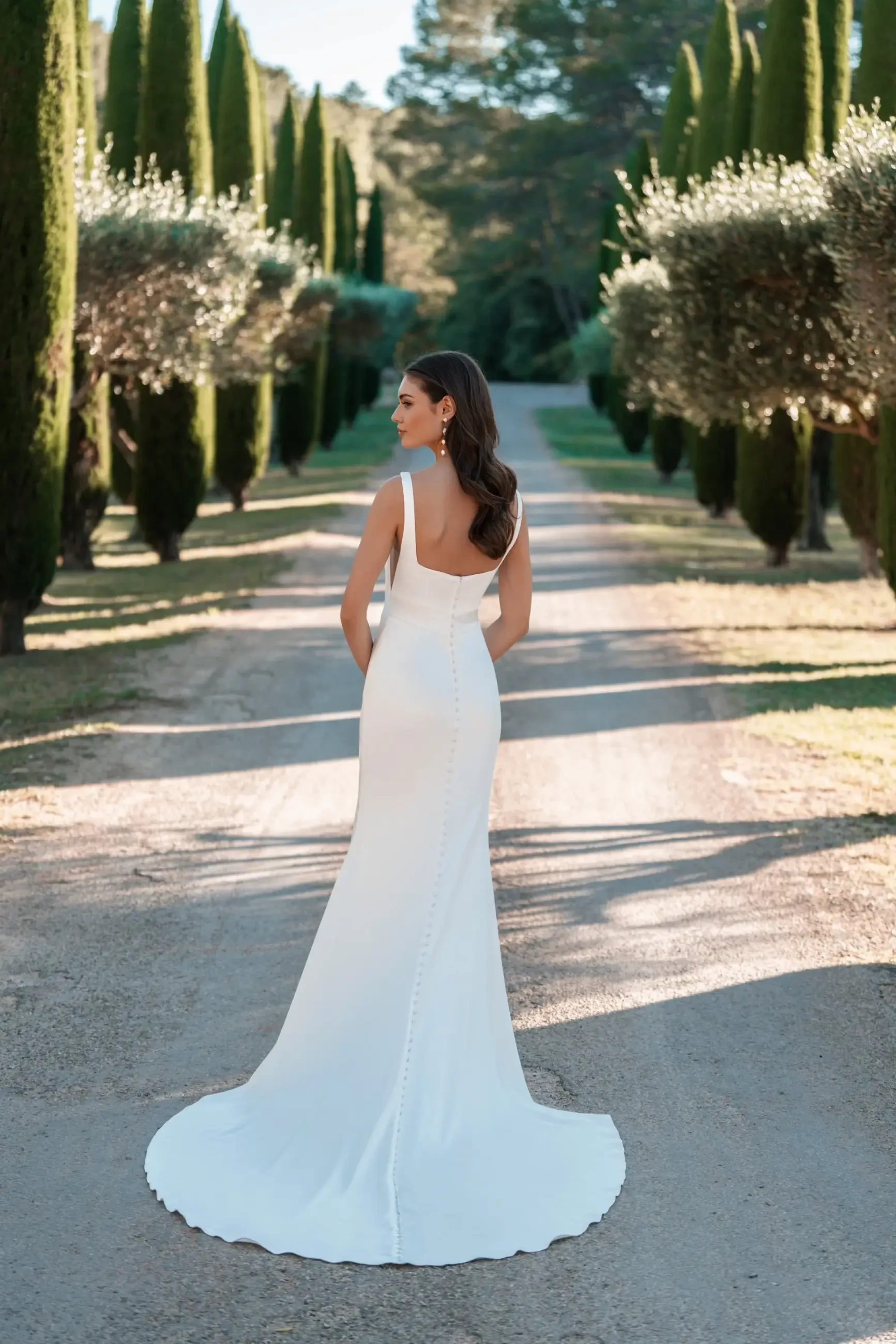 Model is wearing a sleek stretch satin sheath gown perfect for a modern, elegant elopement.