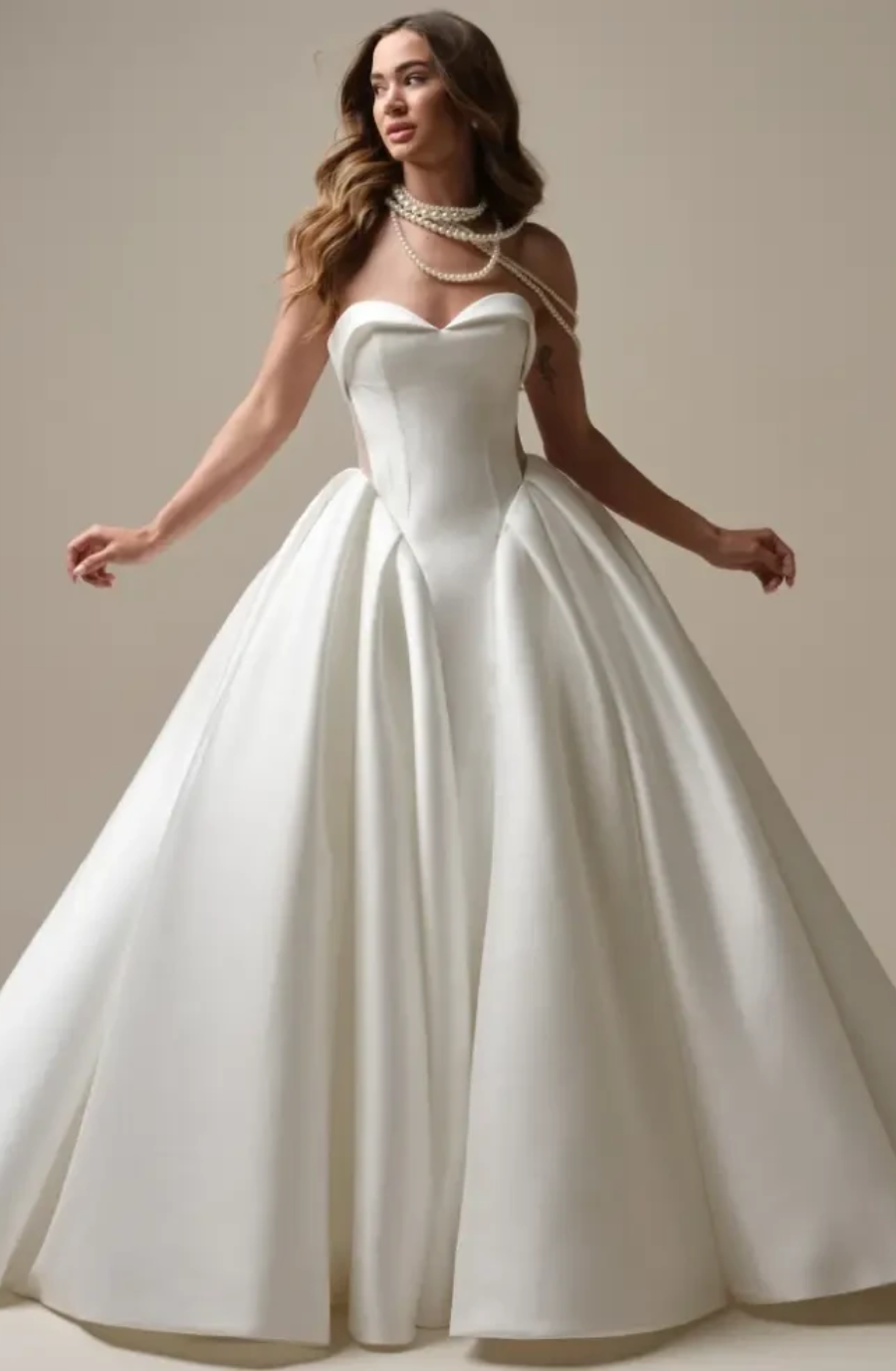 model is wearing a strapless basque waist ball gown