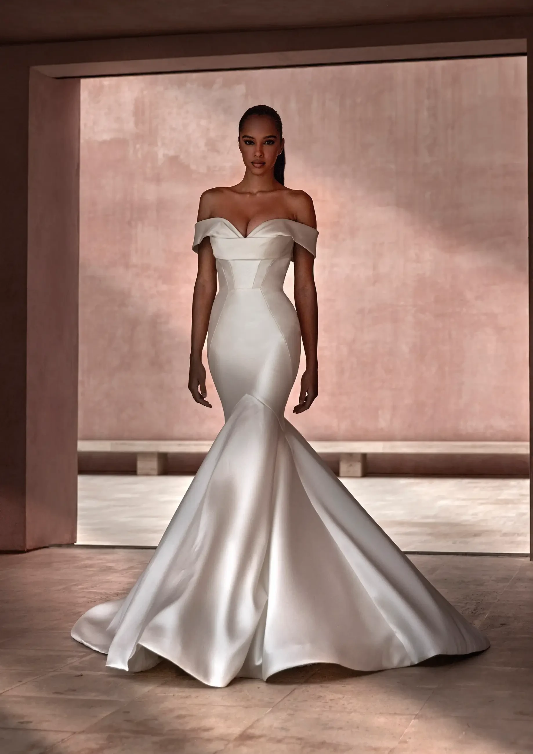 model is wearing an off the shoulder mermaid wedding dress