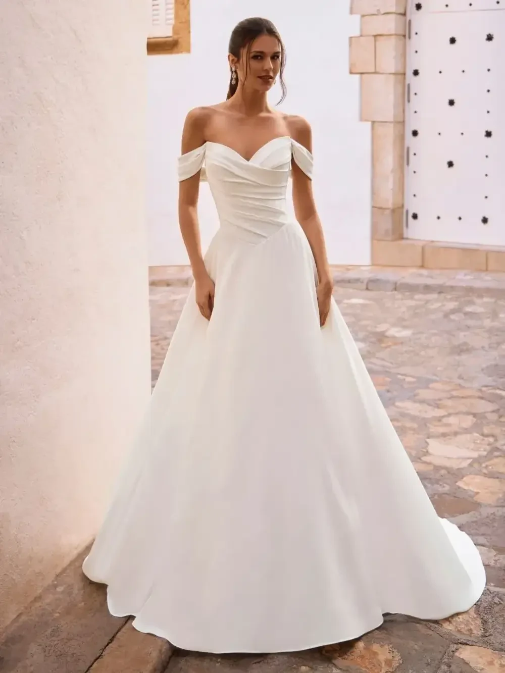 model is wearing an off the shoulder romantic a-line wedding dress