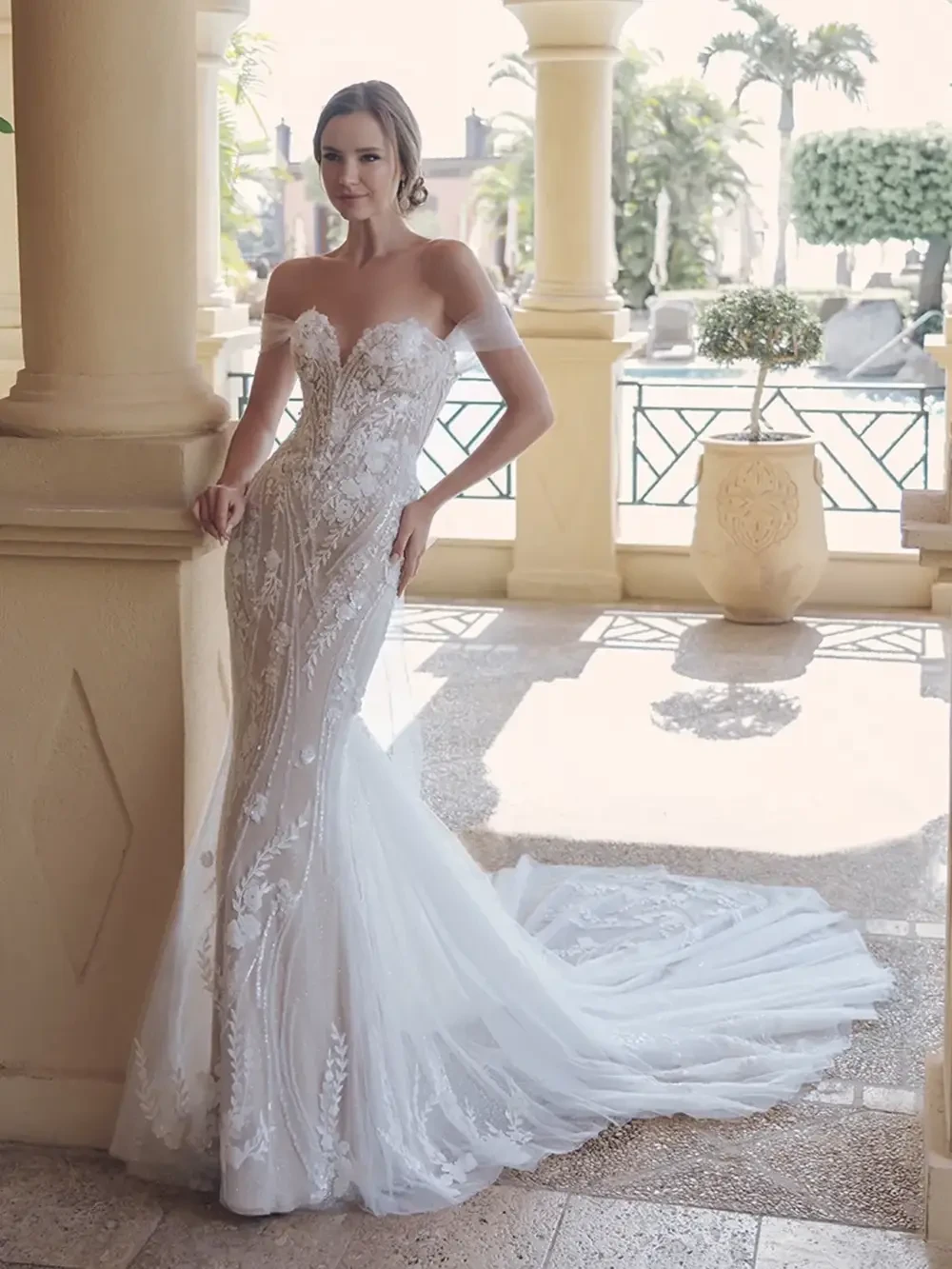 model is wearing a lace off the shoulder bridal gown