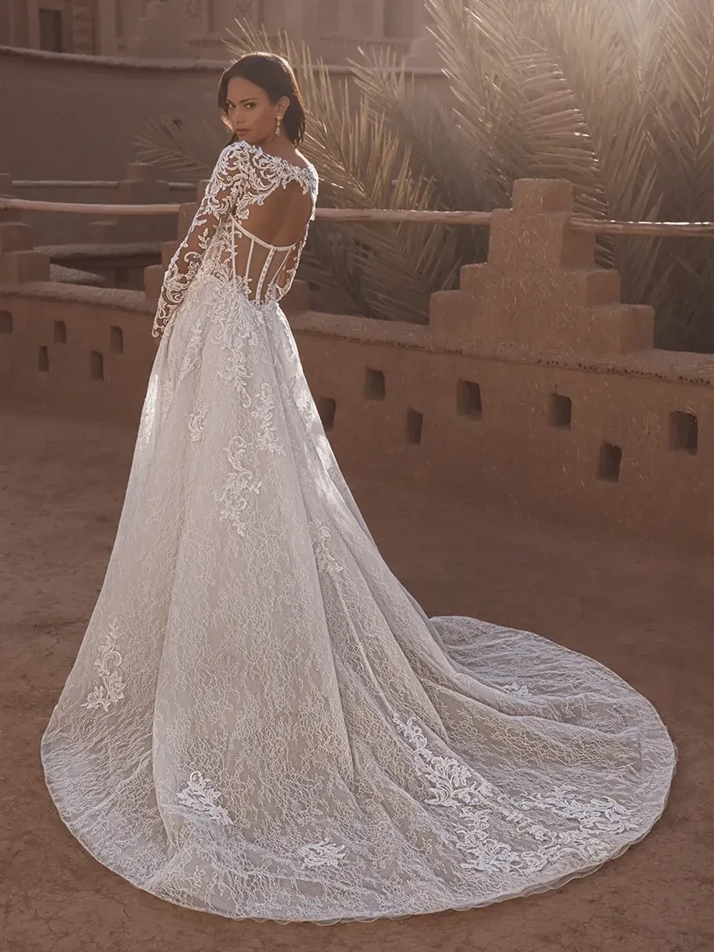 model is wearing a lace long sleeve wedding dress