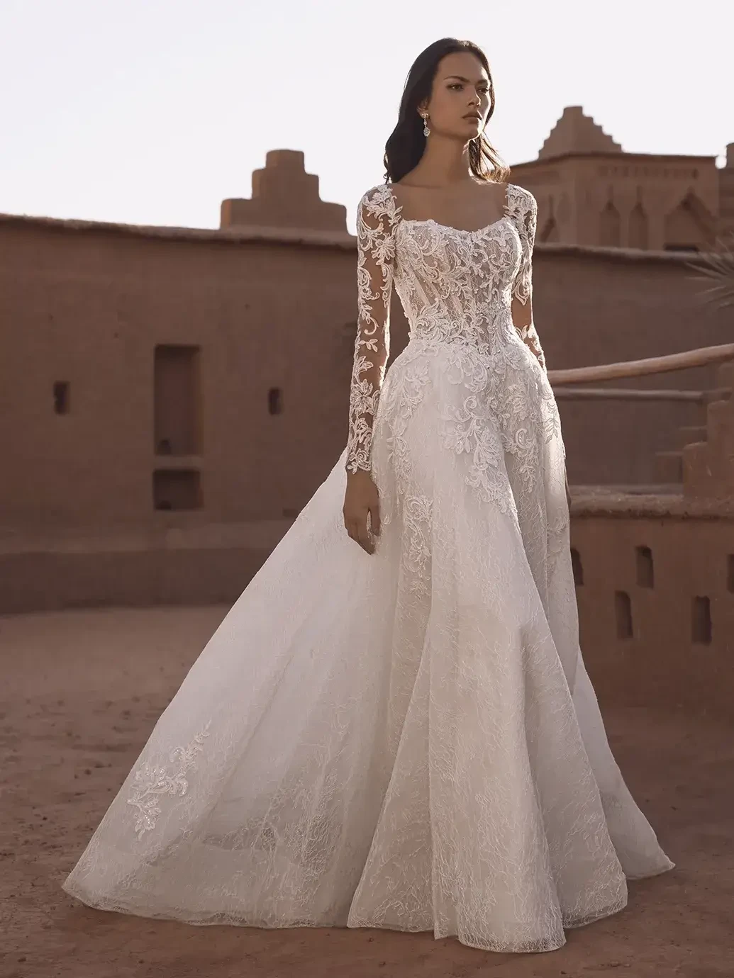 model is wearing a lace long sleeve wedding dress