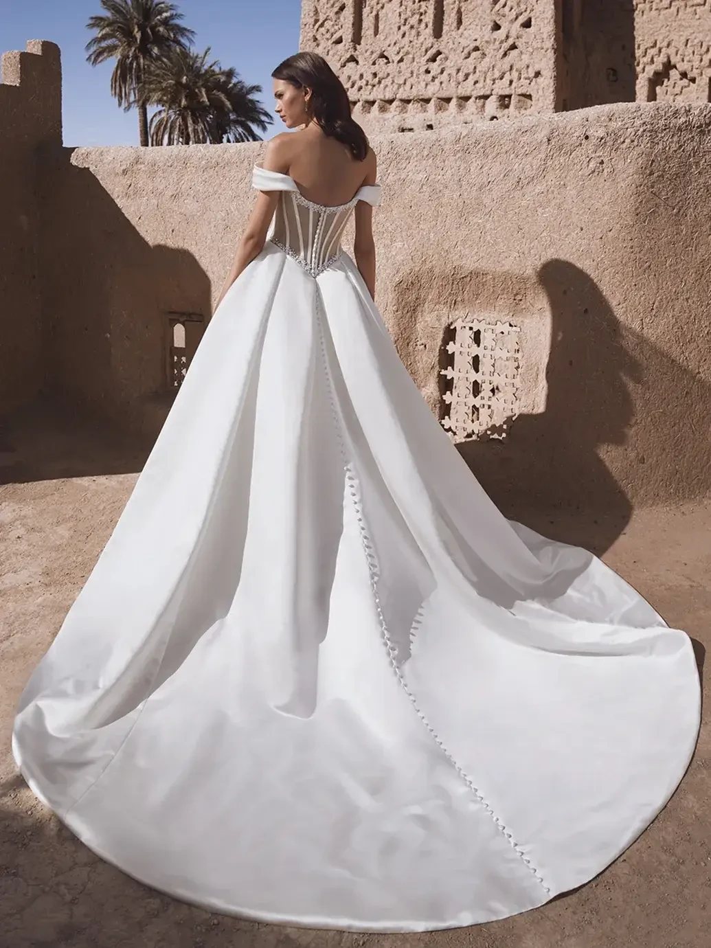 model is wearing an off the shoulder ball gown wedding dress