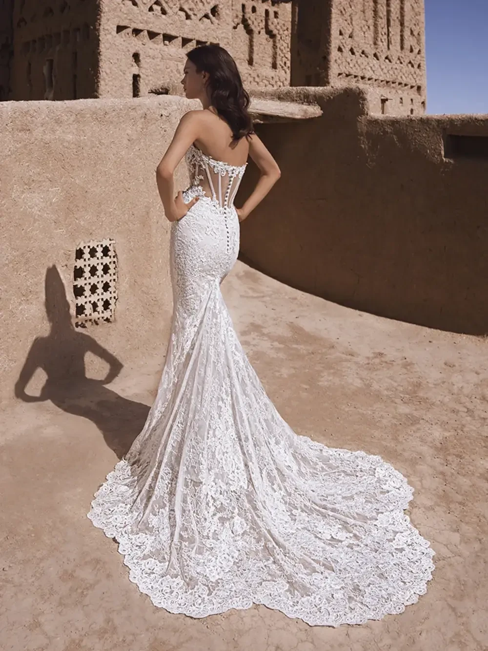 model is wearing a strapless lace fit and flare bridal gown