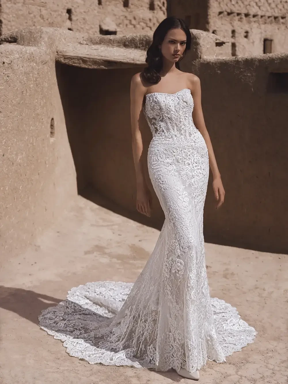 model is wearing a strapless lace fit and flare bridal gown