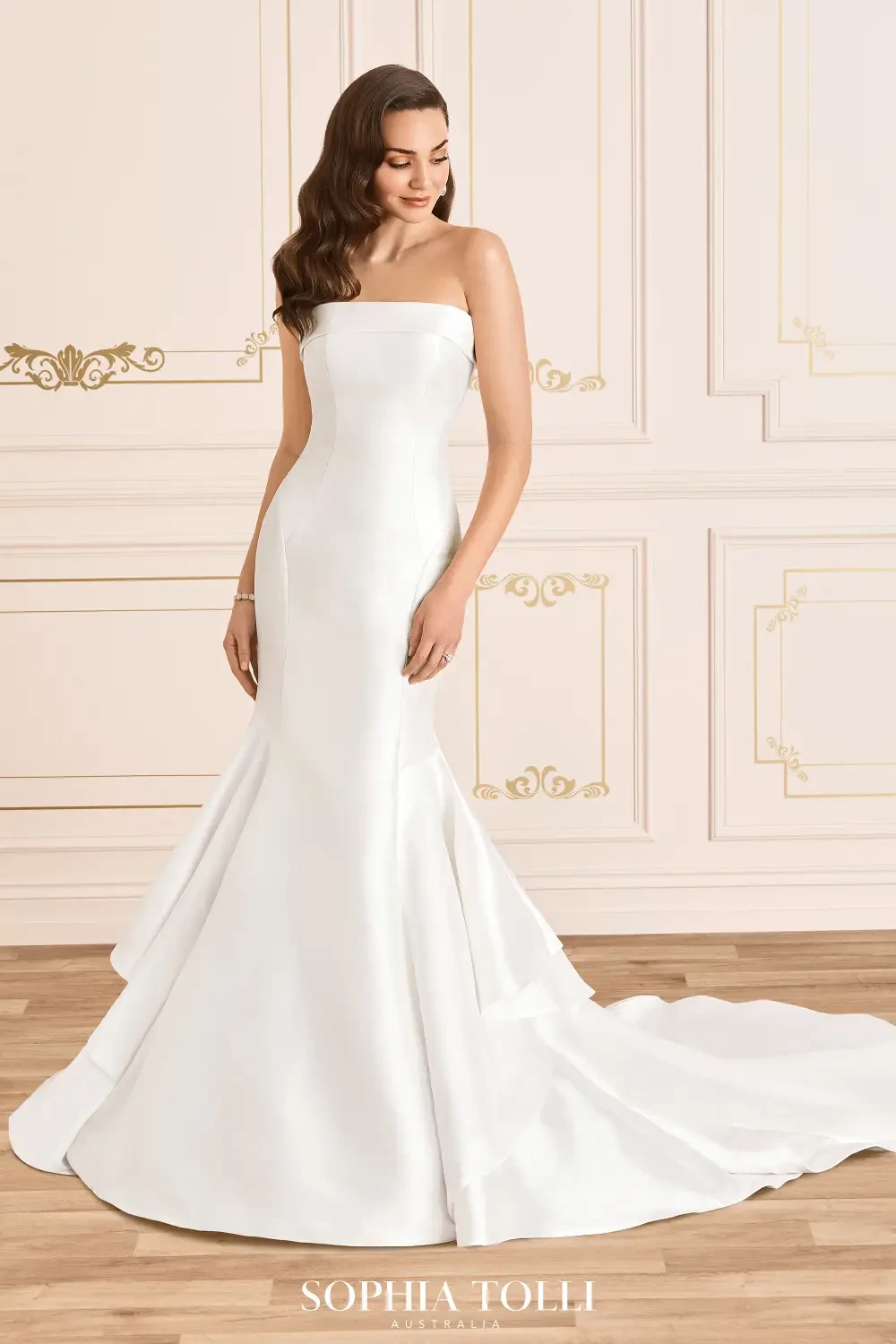 model is wearing a satin strapless fit and flare wedding dress